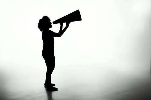 Person with a megaphone. A photo by Patrick Fore on Unsplash